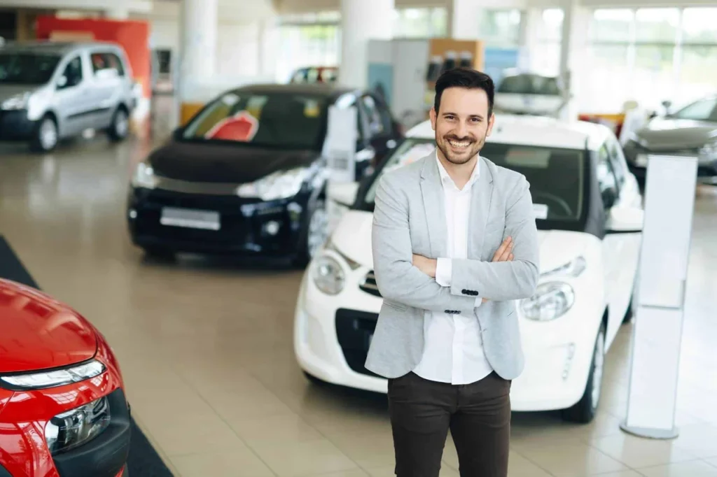 Venda de carros usados: conheça as melhores formas 7 Imagem de homem sorridente em concessionária