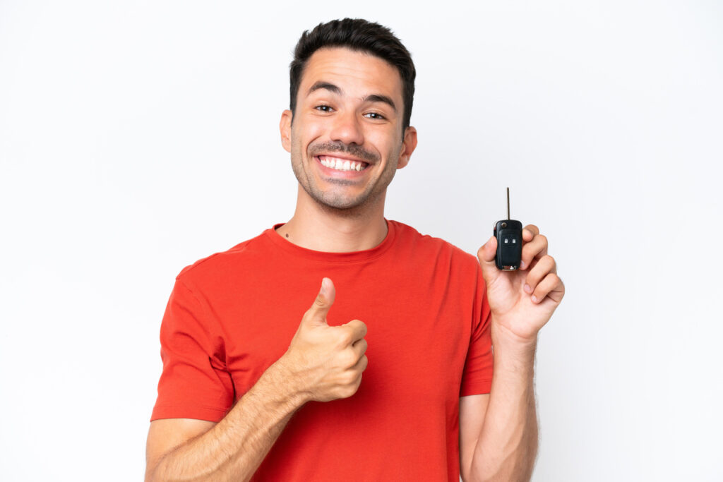 Vender Carro em Barueri: Guia Completo para uma Venda Rápida e Segura 8 Vender seu carro em Barueri - um homem jovem, sorridente, com camiseta vermelha e segurando uma chave de carro na mão